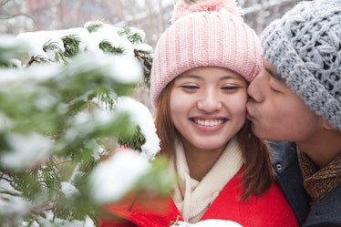 Young Asian couple kiss in snow