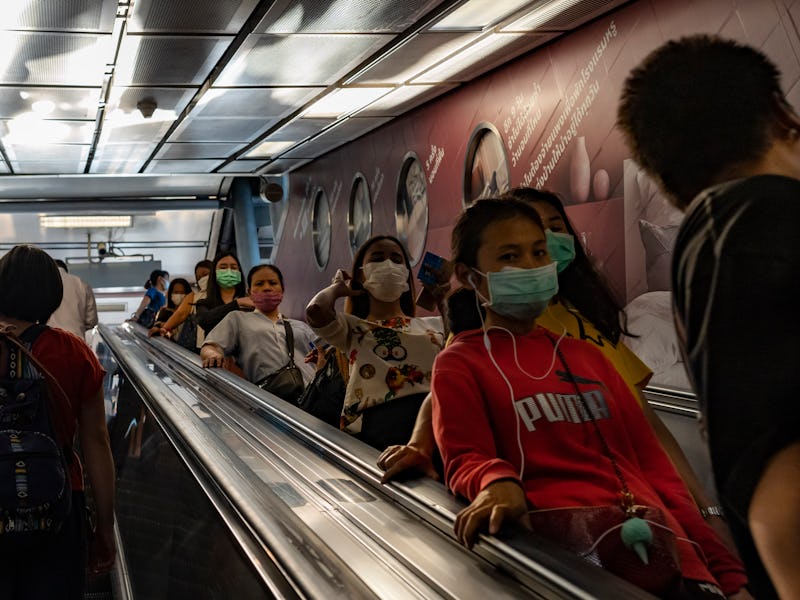 People walk while wearing protective face masks due to concern over the spread of coronavirus in Ban...