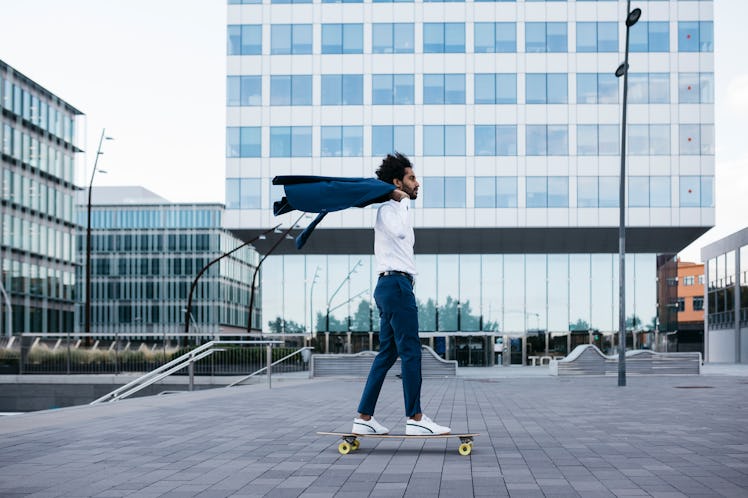 A businessman riding on a skateboard 