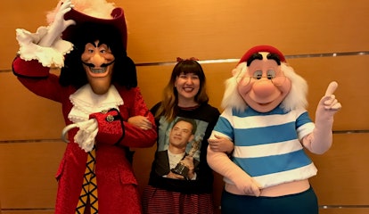 A woman smiles with Captain Hook and Mr Smee on the Disney Cruise. 