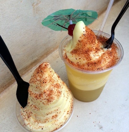 Two dole whips with off the menu tajin seasoning have forks and spoons in them at Disneyland. 