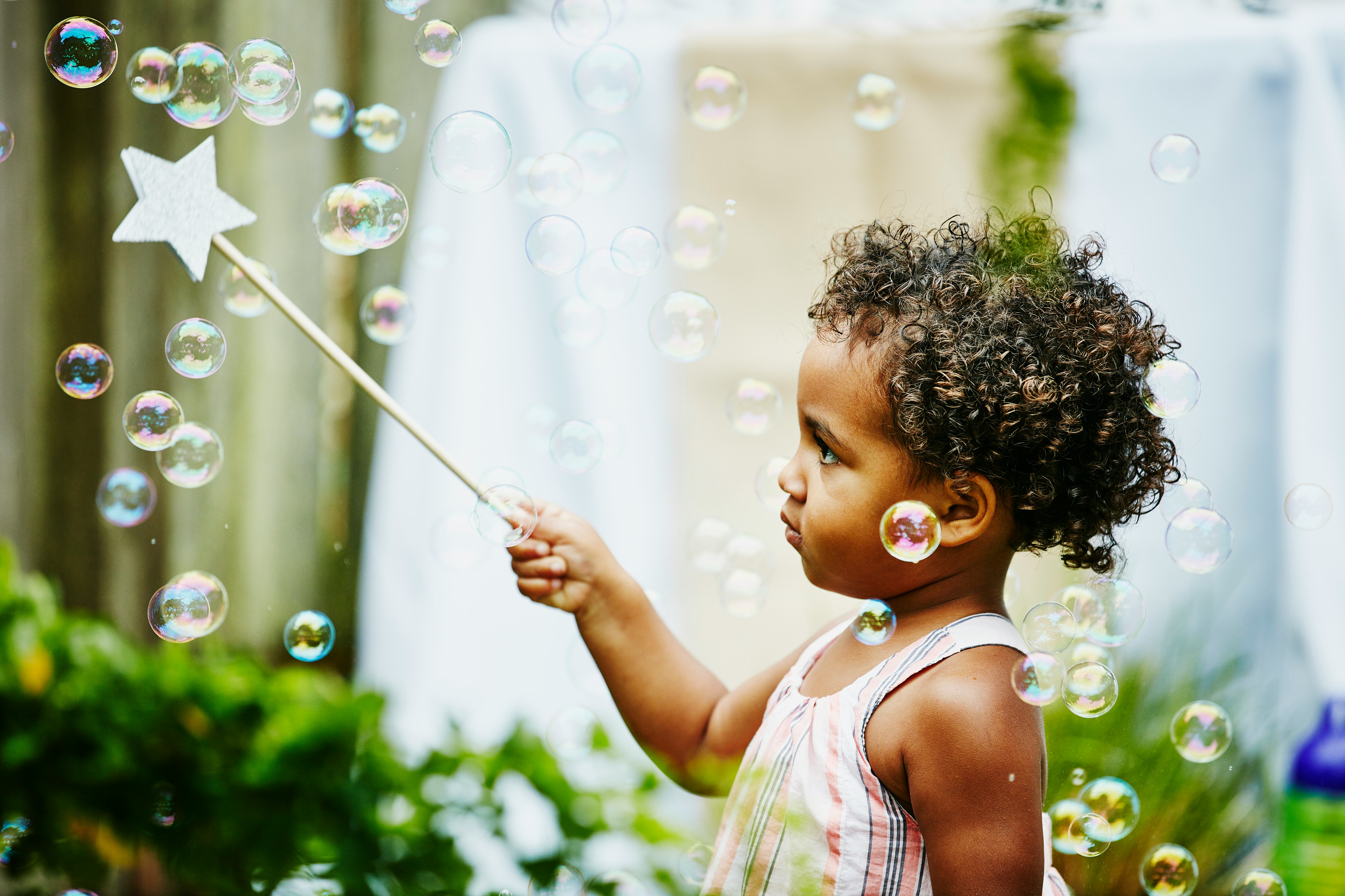 A young girl pops bubbles