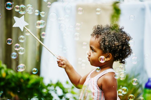 A young girl pops bubbles