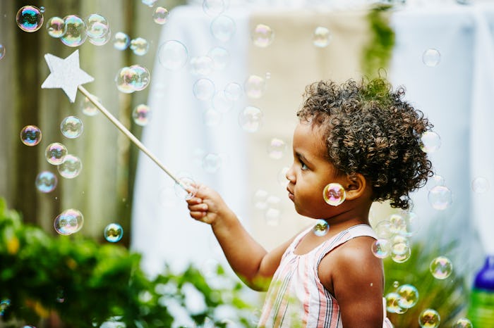 A young girl pops bubbles