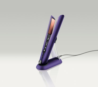 A purple Dyson Corrale straightener resting on its charging platform