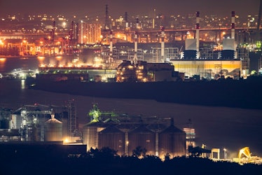 Aerial view of industrial area, factory, port and harbour in Bangkok city, Thailand at night time.