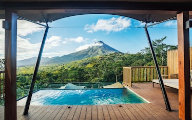 Nayara Tented Camp features a luxurious pool on a deck that overlooks the volcanoes and green mounta...