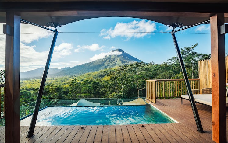 Nayara Tented Camp features a luxurious pool on a deck that overlooks the volcanoes and green mounta...