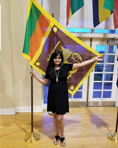 Berea College student Ishara Nanayakkara standing with a flag
