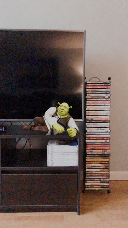 Shrek lounges on a television stand thanks to an Instagram story filter.
