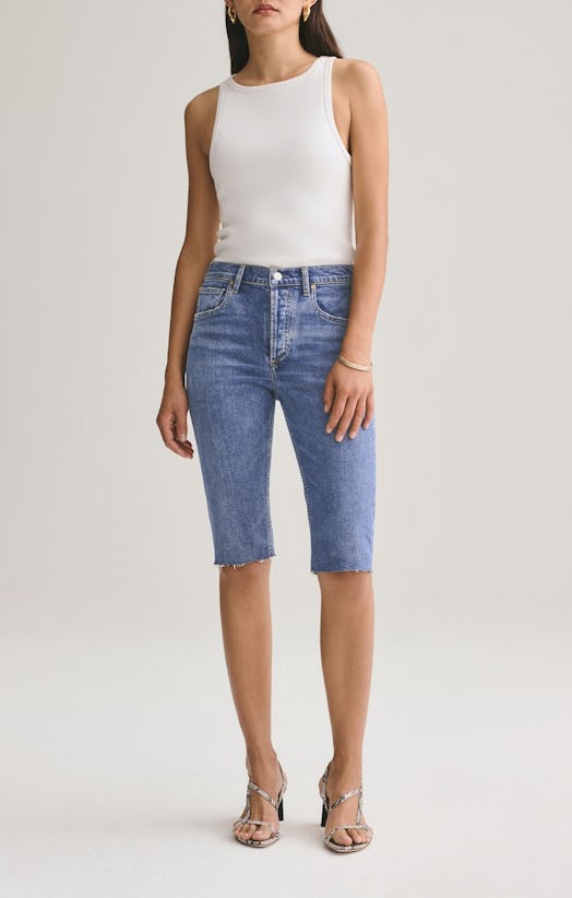 The model wears Carrie Long Length Slim Short by AGOLDE and a white top.
