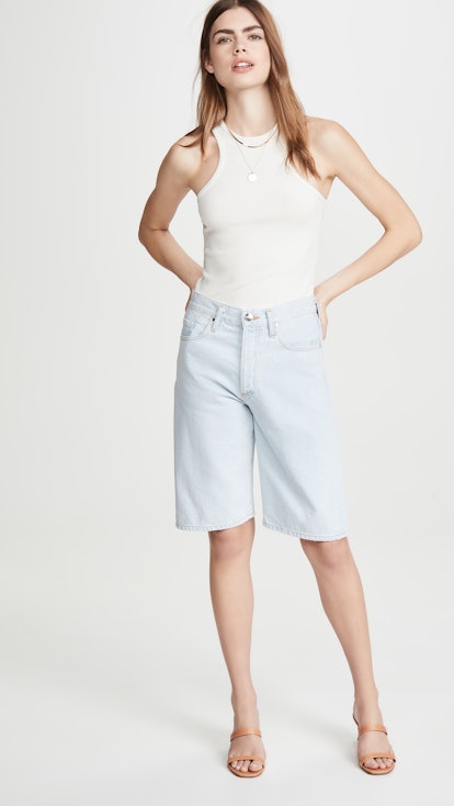 The model wears a light-wash long denim shorts by Shopbop