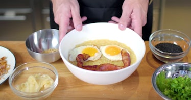 A pair of hands holds onto a bowl of congee inspired by Disney's 'Mulan,' with a smiling bacon and e...
