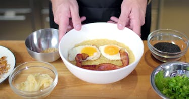 A pair of hands holds onto a bowl of congee inspired by Disney's 'Mulan,' with a smiling bacon and e...