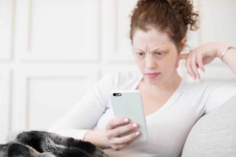 A woman looking at her cellphone with a concerned face. When you work from home, you have to define ...