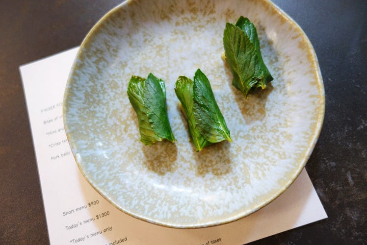 A neutral colored plate has three pieces of spearmint mochi at a restaurant in Mexico City.