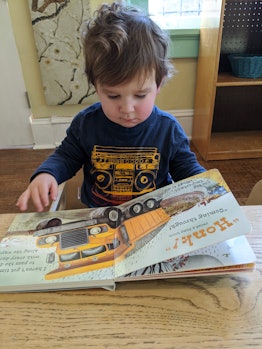 why do books calm my toddler down, toddler reading a book at a table