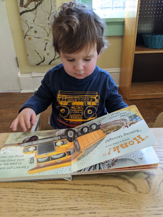 why do books calm my toddler down, toddler reading a book at a table