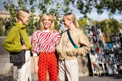Three blond women wearing their best fashion buys for March 2020 while standing on the street