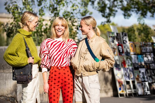 Three blond women wearing their best fashion buys for March 2020 while standing on the street