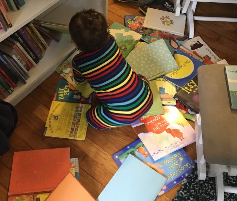 why do books calm my toddler down, toddler sitting in a pile of books
