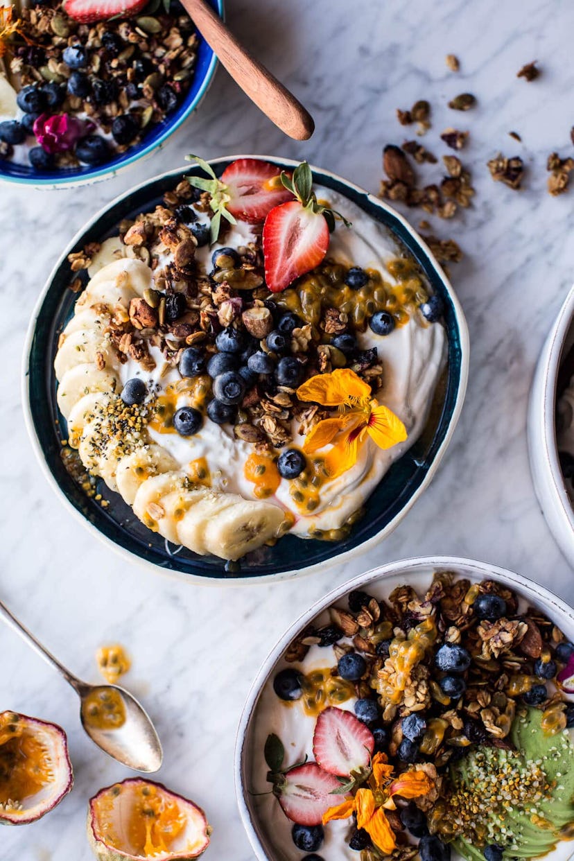 A bowl of granola with yogurt and fruit.