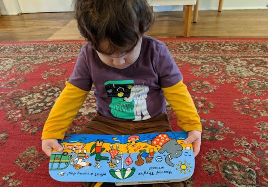 photo of toddler with book in hand