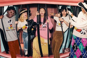 A group of friends wearing the Disney x Gucci collection laugh while standing in Toontown at Disneyl...