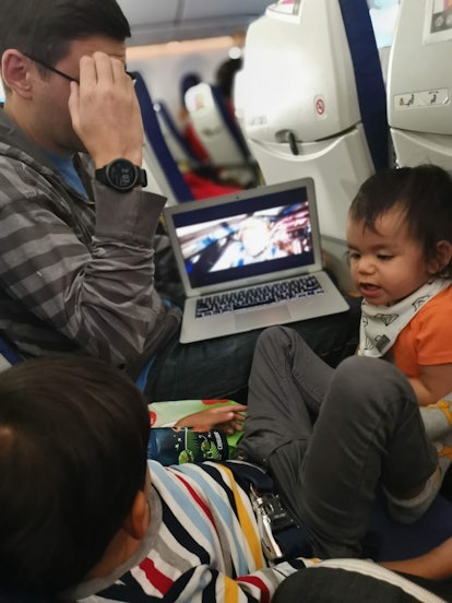 A father and child play on an airplane