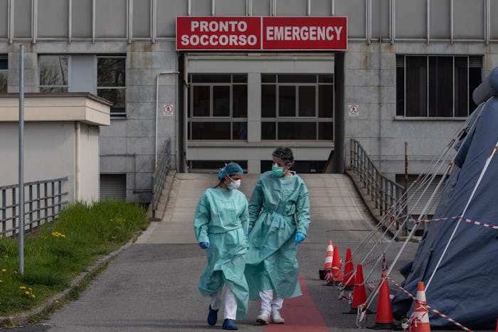Two nurses walk in front of the Emergency Room of a hospital near Milan