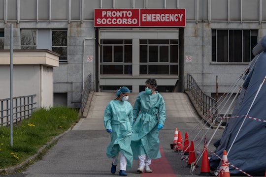Two nurses walk in front of the Emergency Room of a hospital near Milan
