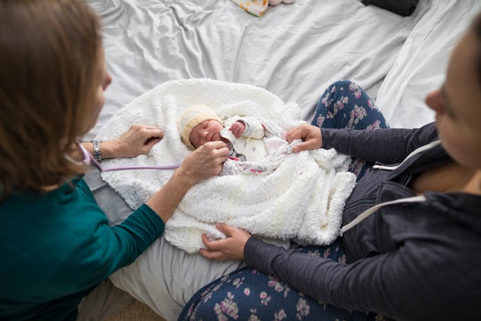 A midwife with a mother and newborn