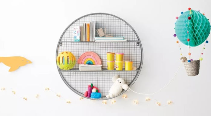Grey round metal shelf with various kids toys displayed