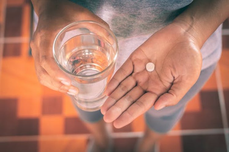 Close Up Of Girl holding Paracetamol and glass of water.