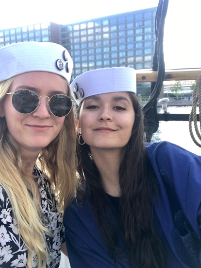 Two women in sailor's hats pose for a selfie on a sunny day in Copenhagen, Denmark.