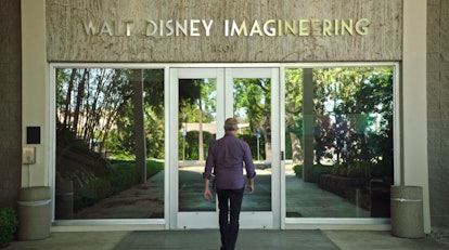 A man walks into the front doors of the Disney Imagineering building in California. 
