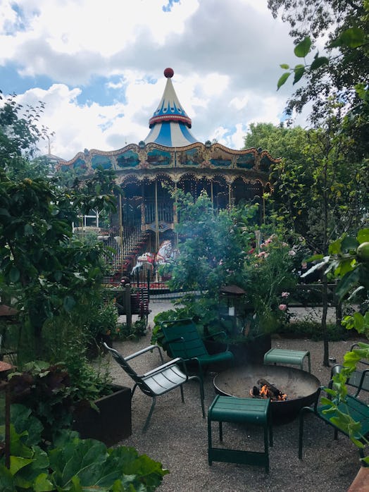 A beautiful carousel is surrounded by greenery at the Tivoli Gardens in Copenhagen, Denmark.