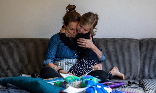 a little girl on her mom's lap, reading books