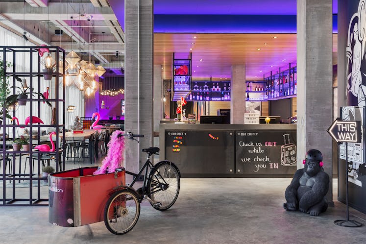 The interior of Moxy Copenhagen has pink flamingo decor and a cool bar with purple lights.