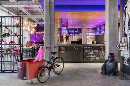 The interior of Moxy Copenhagen has pink flamingo decor and a cool bar with purple lights.