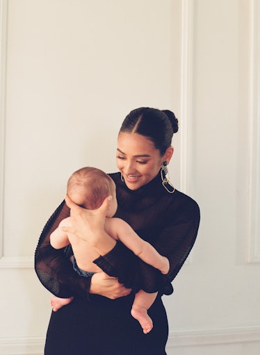 Shay Mitchell holding her baby and smiling while wearing Stella McCartney bloomers.