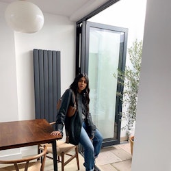 A fashion insider leaning on her table while wearing a leather jacket and jeans