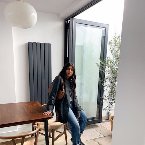 A fashion insider leaning on her table while wearing a leather jacket and jeans