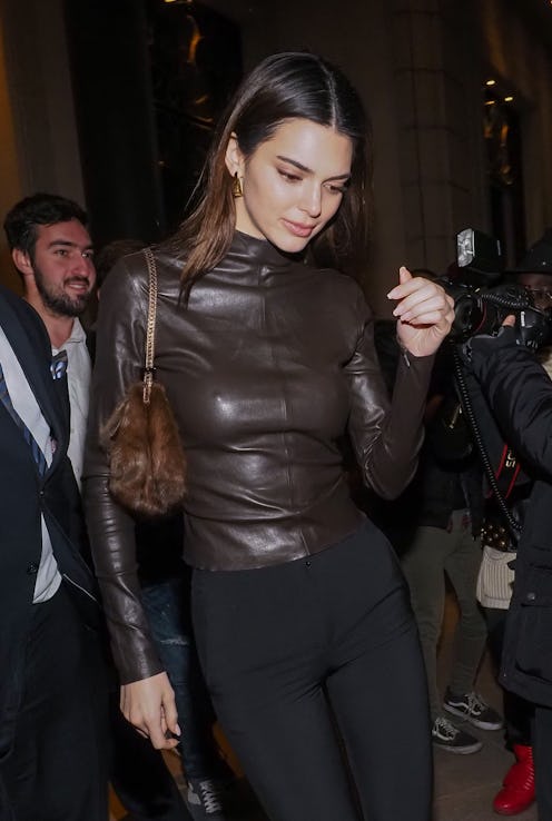 Kendall Jenner wearing black pants and a brown leather shirt