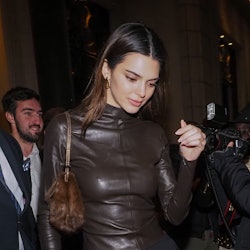 Kendall Jenner wearing black pants and a brown leather shirt