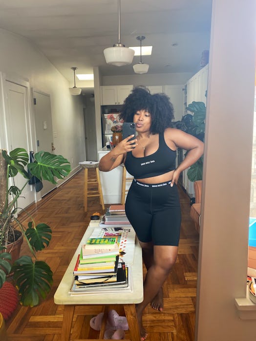 A curly woman taking a selfie in black activewear for working from home