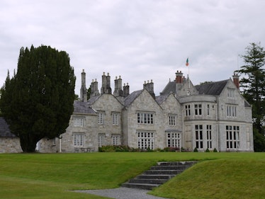 Lough Rynn Castle in Ireland features a stone exterior and massive green lawn. 