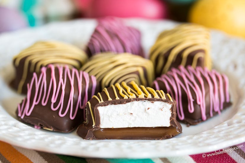 White plate with several chocolate squares with colorful drizzle over them and one in the center tha...