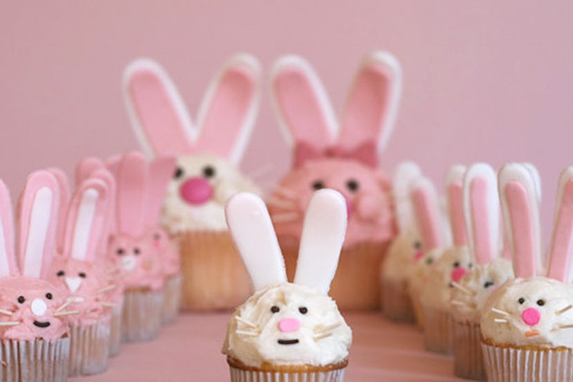Several cupcakes with pink or white frosting and decoration to look like bunny faces