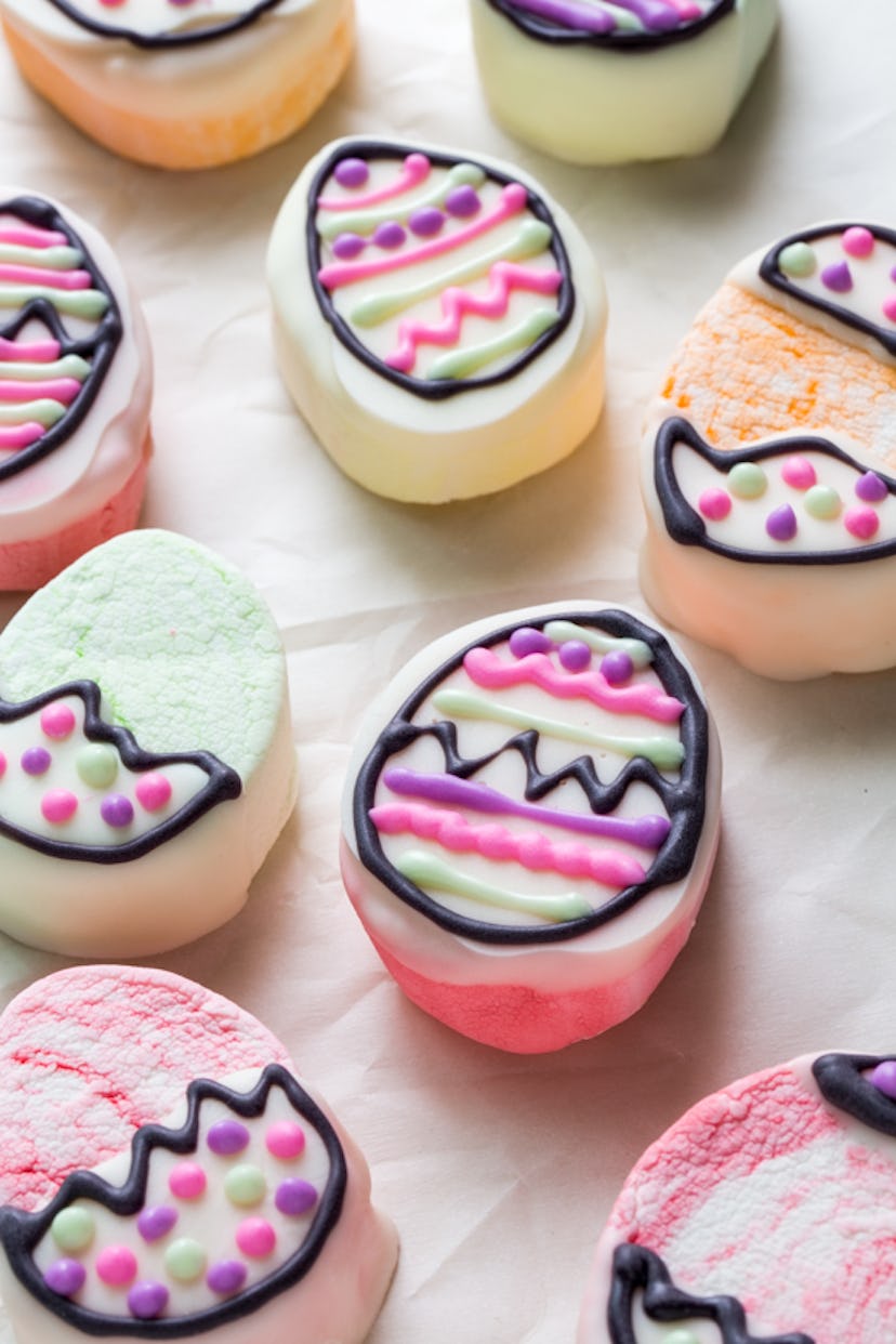 Several homemade marshmallow eggs topped with decorative frosting